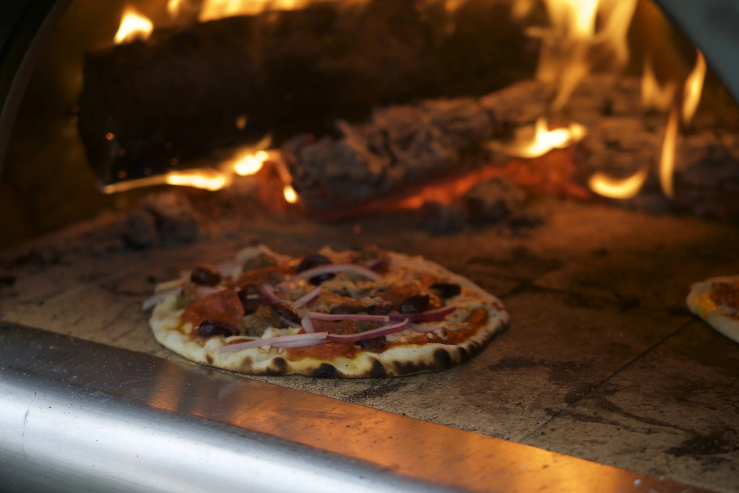 Wood-fired pizza being prepared