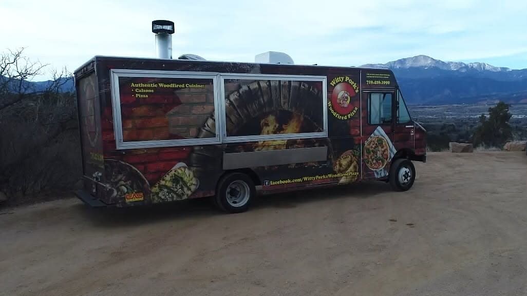 The Witty Pork's wood-fired pizza truck parked with the Colorado mountains behind it
